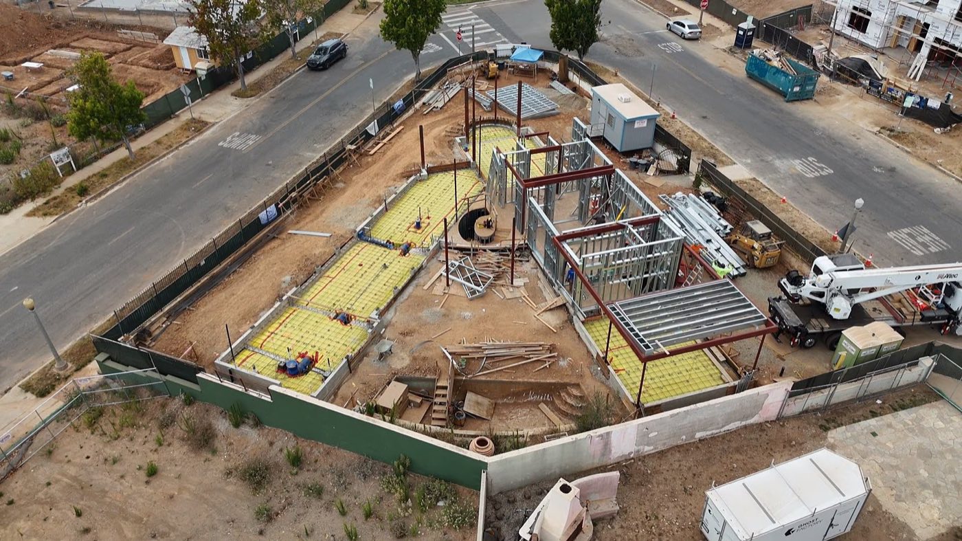 Aerial of a Palisades rebuild: structural steel and light-gauge steel framing across the site